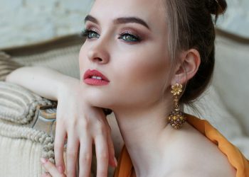 Stunning close-up portrait of a woman with elegant makeup and jewelry, epitomizing modern fashion and beauty.
