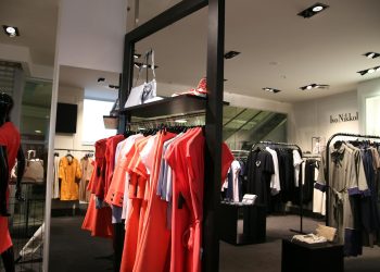Discover a chic fashion boutique showcasing a variety of colorful clothes on elegant racks.