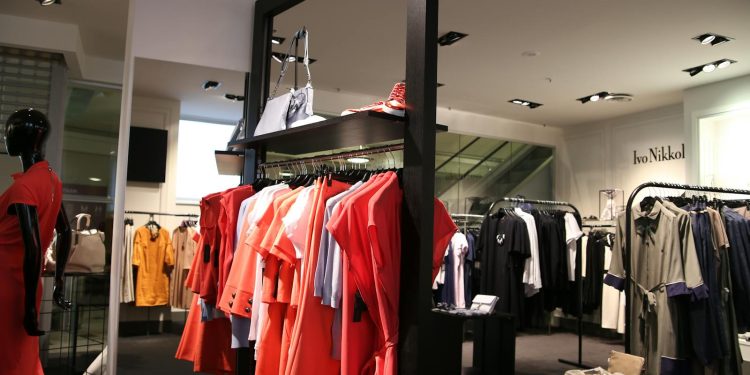 Discover a chic fashion boutique showcasing a variety of colorful clothes on elegant racks.